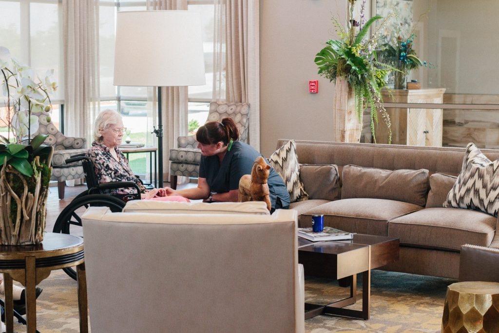 A woman speaking to a nurse in the lobby of a respite care facility