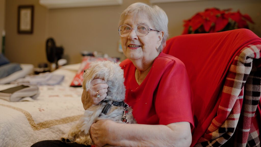 A woman at a skilled nursing facility holding a dog