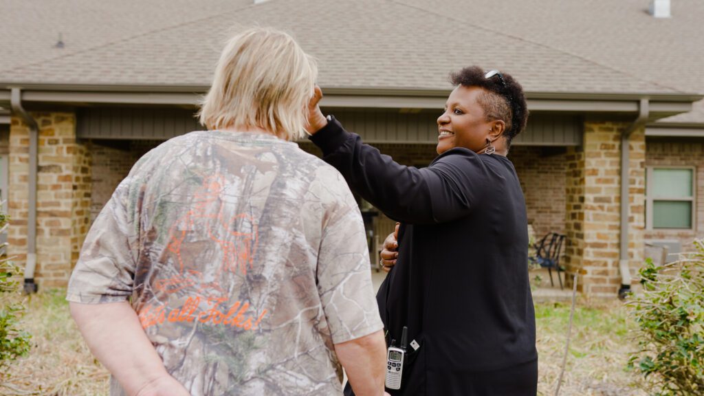 A nurse speaks to a family member at a skilled nursing nursing home